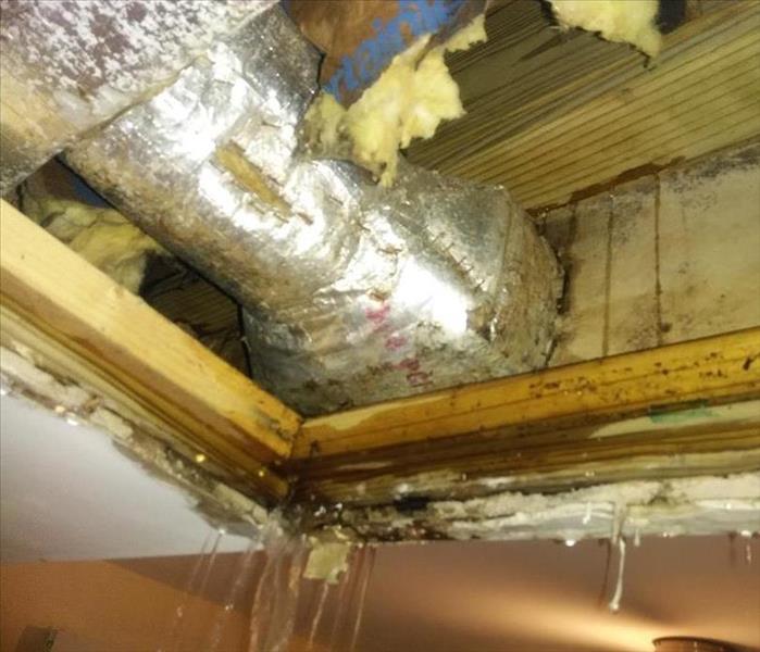 water flooding out of leaking pipe in ceiling