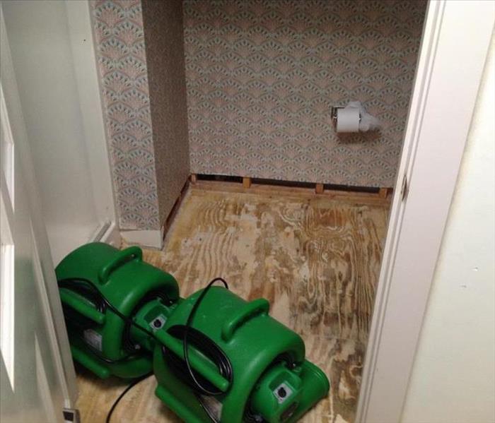 fans in bathroom with water damage removed and showing sub-floor