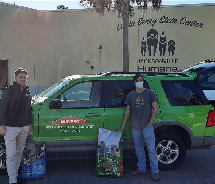 Humane Society reps and SERVPRO personnel with puppy Thunder in front of SERVPRO car